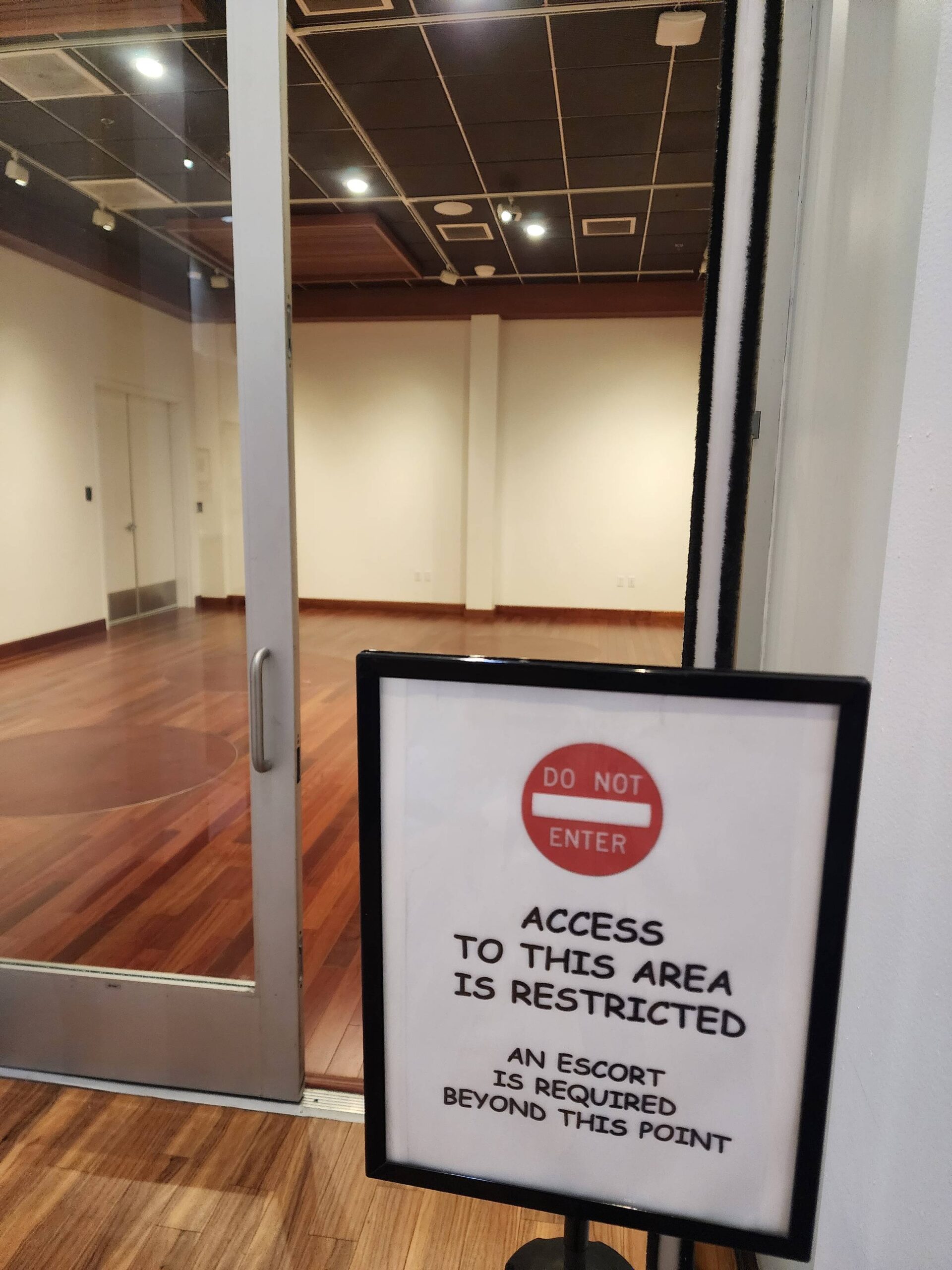 A "restricted access" sign at the entrance to the empty exhibit hall.
